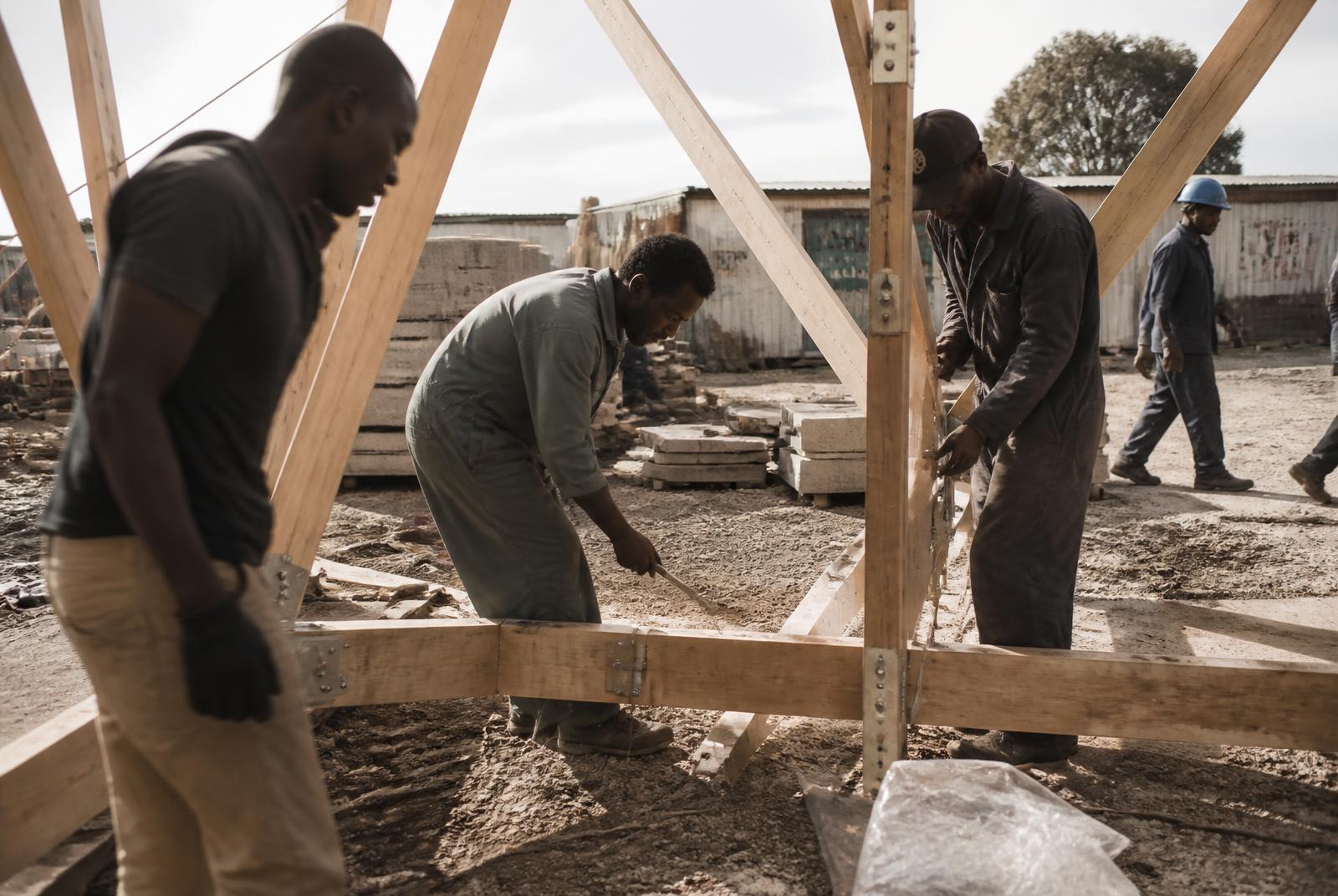 Hands working together on a timber structure on site