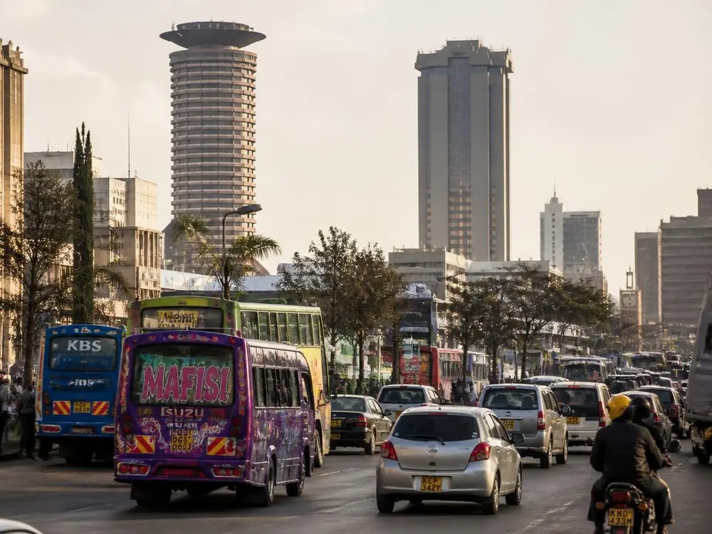 Nairobi city traffic and matatus beneath modernist towers